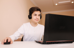 Teen wearing headphones using laptop