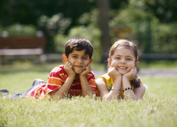 Children lying in grass at a park