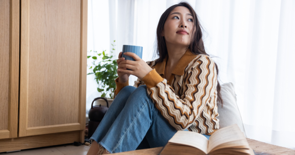 Woman relaxing with a cup of tea and a book.