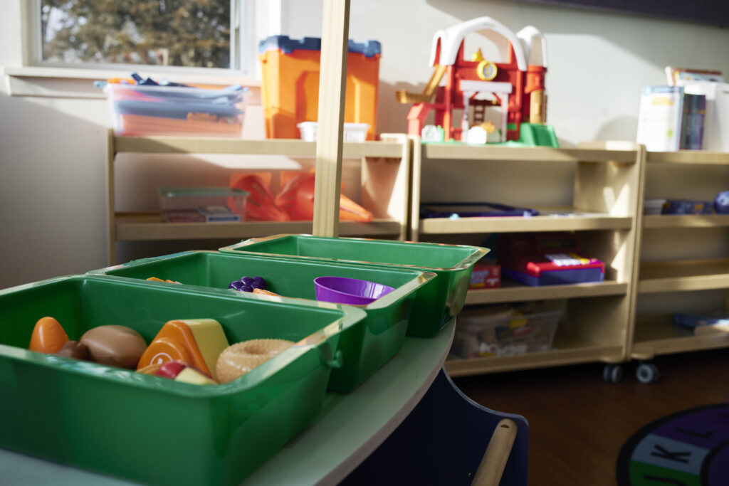 Colouful toys in buckets on a desk, and in organizers along a wall.