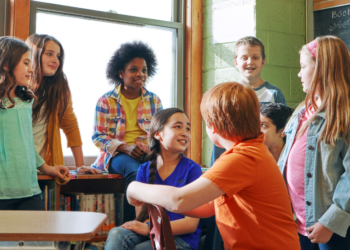 Group of kids chatting in a classroom.